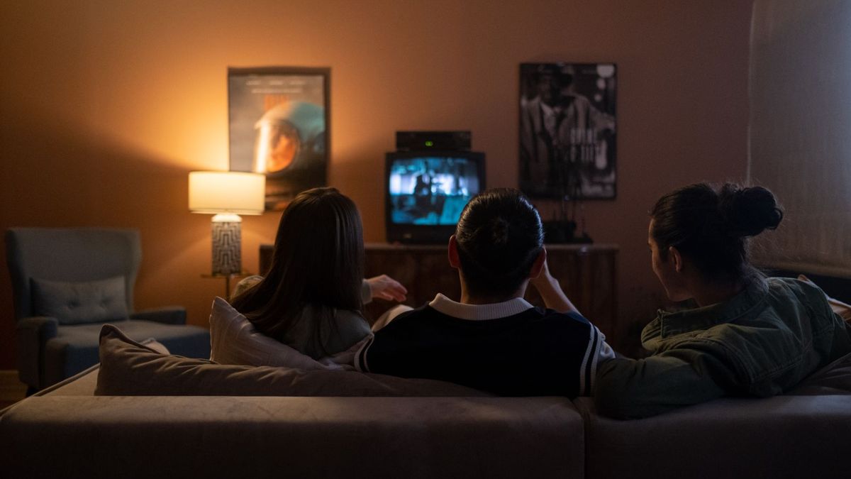 Rodzina oglądająca telewizję wieczorem w salonie