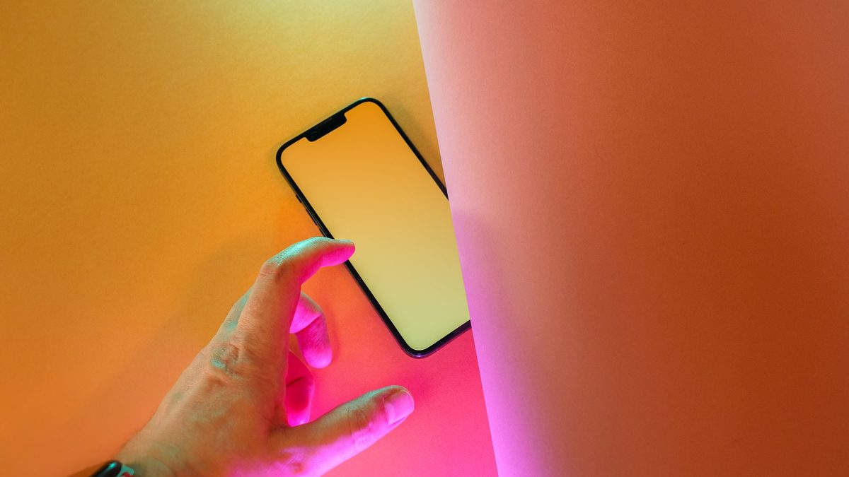 Dłoń sięga po smartfon, żeby zalogować się bez hasła